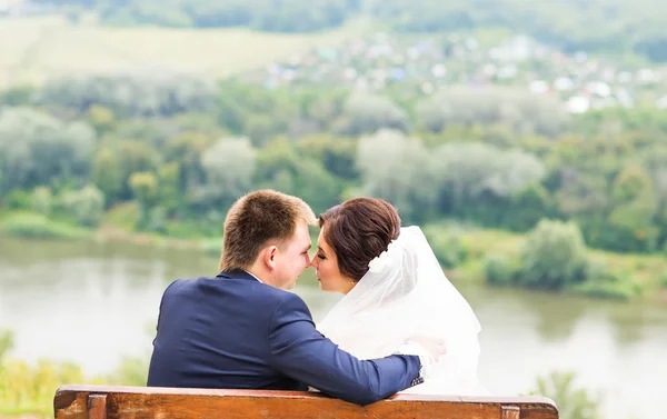 Mariage Mariée et marié sur un banc avec paysage nature arrière-plan. — Photo