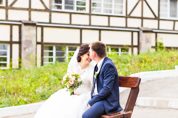 公園のベンチに座ってロマンチックな結婚式のカップル — ストック写真