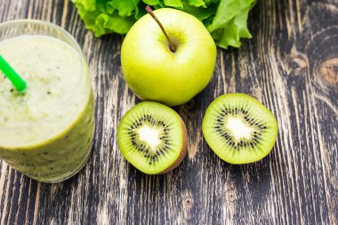 Kivi ve ahşap arka plan üzerinde elma ile sağlıklı yeşil smoothie