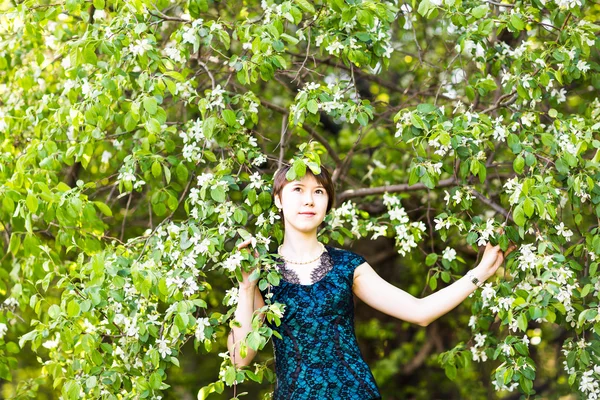 Краса, люди, концепція літа та весни - красива молода жінка на зеленому квітучому садовому фоні — стокове фото
