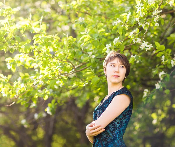 Beauté, personnes, concept d'été et de printemps - belle jeune femme sur fond de jardin fleuri vert — Photo
