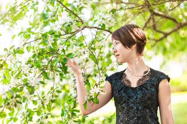 Skönhet, människor, sommaren och våren koncept - vacker ung kvinna över gröna blommande trädgård bakgrund — Stockfoto