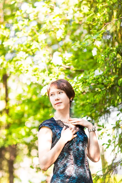 Portrait de fille de printemps. Femme asiatique souriant heureux le jour ensoleillé d'été ou de printemps à l'extérieur dans le jardin d'arbres à fleurs. Jolie mixte race Caucasienne ou chinoise asiatique jeune femme en plein air . — Photo