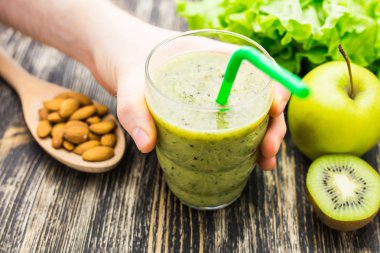 Kivi ve ahşap arka plan üzerinde elma ile sağlıklı yeşil smoothie