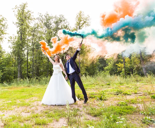 Pareja de boda con humo de color en el parque de verano . —  Fotos de Stock