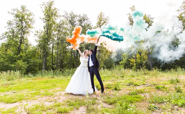 Casamento casal com fumaça de cor no parque de verão . — Fotografia de Stock