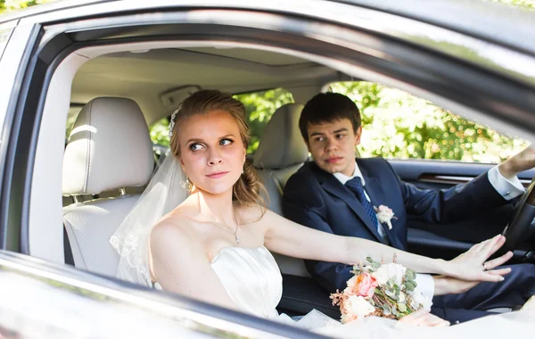Bride and groom inside a  car. They are happy. — Stock Photo, Image