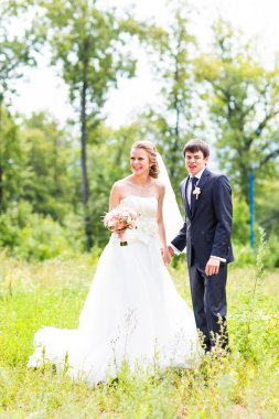 Gelin ve damat dışarıda el ele tutuşuyorlar.