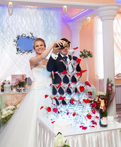 Bruid en bruidegom gieten champagne in het glas — Stockfoto