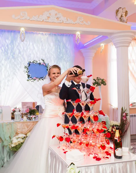 Bruid en bruidegom gieten champagne in het glas — Stockfoto