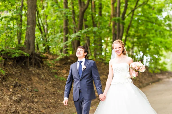 Happy bride and groom at a park on their wedding day — Stock Photo, Image