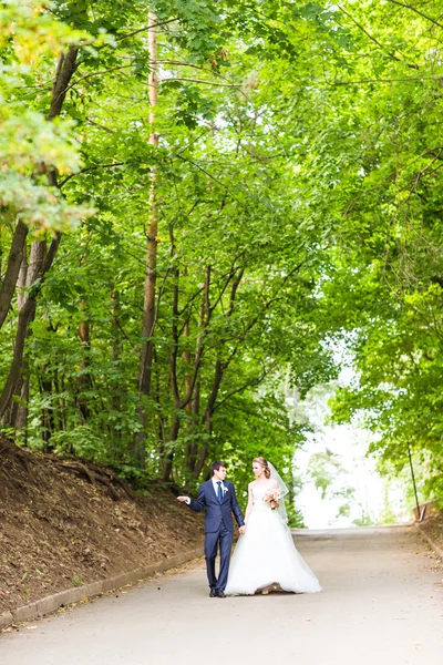 Noiva feliz e noivo em um parque em seu dia do casamento — Fotografia de Stock