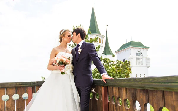 Elegante wunderschöne glückliche Braut und Bräutigam auf dem Balkon stehend — Stockfoto