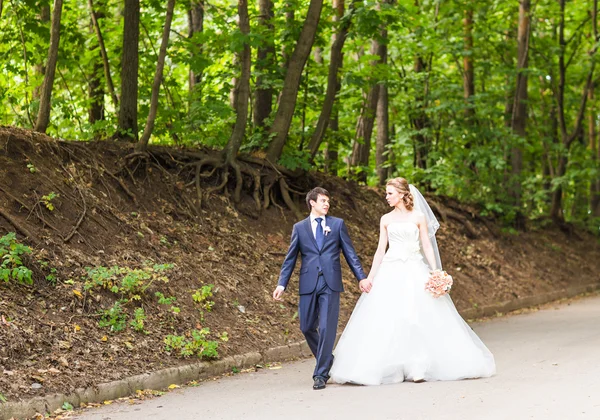 Noiva feliz e noivo em um parque em seu dia do casamento — Fotografia de Stock