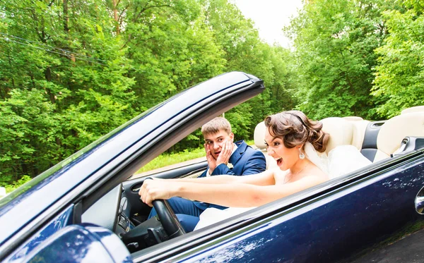 Mooie jonge paar bruid en bruidegom poseren in cabriolet — Stockfoto