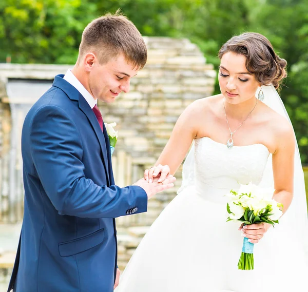 Noivo e noiva está usando um anel no dedo, cerimônia de casamento. Ouro, símbolo, religião, amor . — Fotografia de Stock