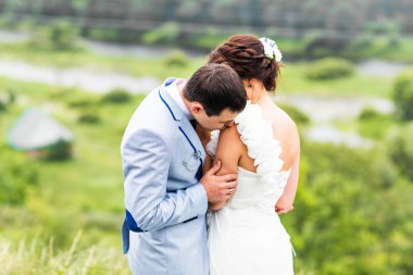 Gelin ve damat gün açık havada yürüyüş düğününde Doğa bahar. Yeşil park kucaklayan mutlu yeni evli.