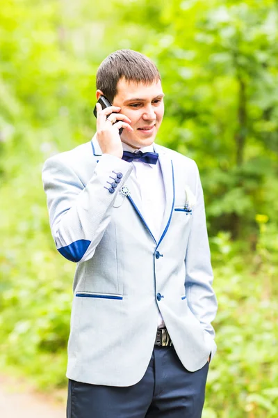 Kaukasische man met mobiele telefoon in de natuur — Stockfoto