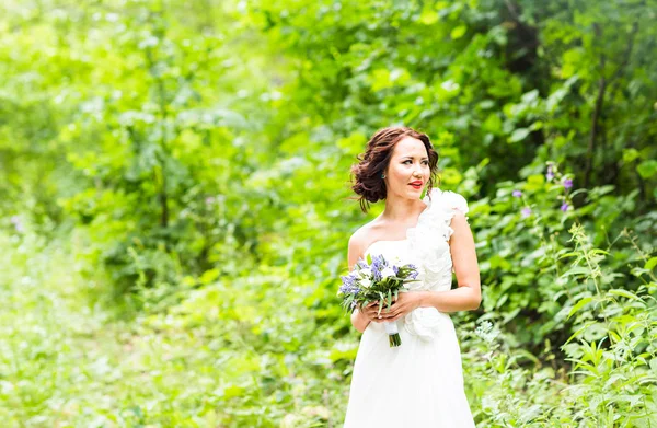Braut hält Strauß weißer Calla-Lilien und blauer Blumen — Stockfoto
