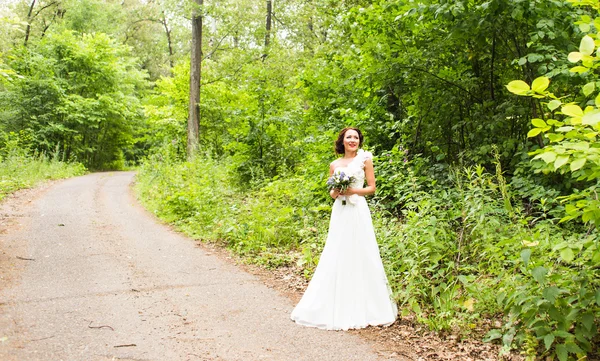 Невеста с букетом белых каллы и голубыми цветами — стоковое фото