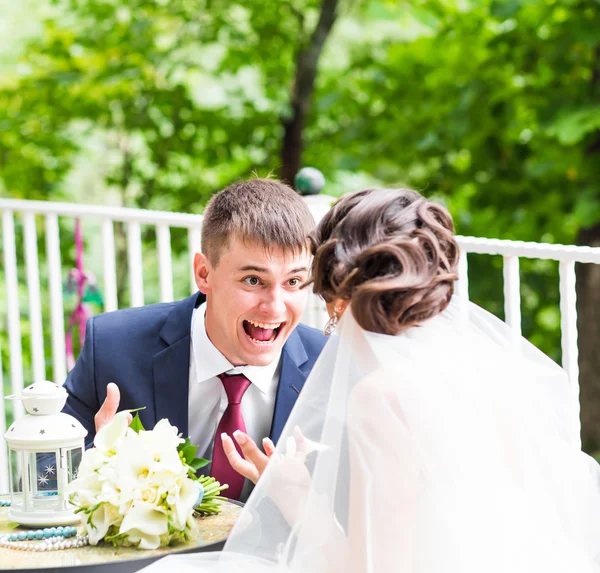 Grappige bruid en gekke bruidegom op het terras van het restaurant — Stockfoto