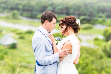 Gelin ve damat gün açık havada yürüyüş düğününde Doğa bahar. Yeşil park kucaklayan mutlu yeni evli.