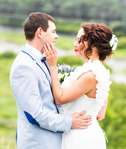 Gelin ve damat gün açık havada yürüyüş düğününde Doğa bahar. Yeşil park kucaklayan mutlu yeni evli.