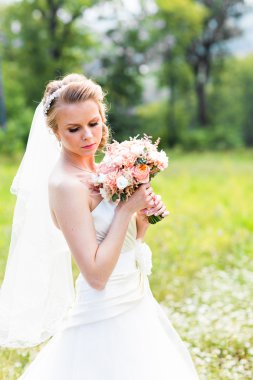 Güzel gelin düğün buket çiçek yeşil park açık havada'ile.