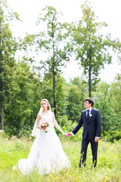 Mariée et marié tenant la main à l'extérieur — Photo