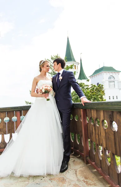 Elegant gorgeous happy  bride and groom standing on the balcony — Stock Photo, Image