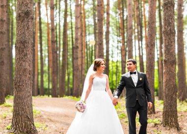 Damat ve gelin bir parkta. Gelin düğün buket çiçek