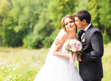 Damat ve gelin bir parkta. Gelin düğün buket çiçek