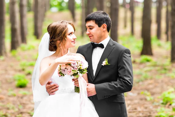 Bruid en bruidegom in een park. Bruidssuite bruiloft boeket van bloemen — Stockfoto
