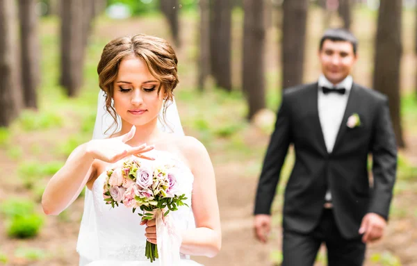 Sposo e sposa in un parco. Bouquet da sposa di fiori — Foto Stock