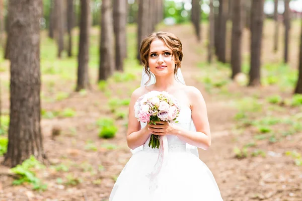 Bela noiva com buquê de flores ao ar livre — Fotografia de Stock
