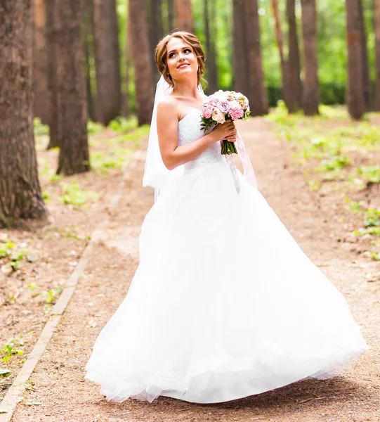 Mooie bruid met boeket van bloemen buiten — Stockfoto