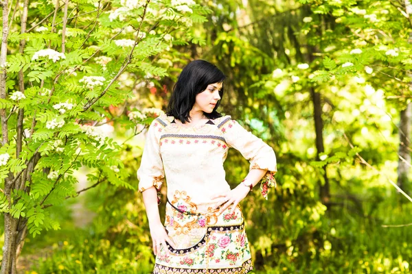 Mulher de primavera em vestido de verão andando no parque verde apreciando o sol. Menina divertida e bonita no dia ensolarado quente . — Fotografia de Stock