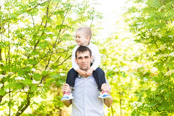 Porträt eines glücklichen Mannes, der seinen Sohn im Freien am Hals hält — Stockfoto