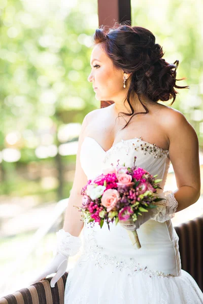 Beautiful bride holding big wedding bouquet — Stock Photo, Image
