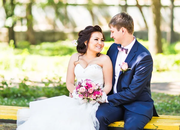Esküvő Menyasszony és vőlegény egy padon a természet táj háttér — Stock Fotó