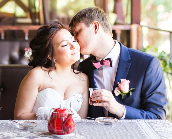 Gelukkige bruid en bruidegom samen in café plezier. Gelukkig jonggehuwde paar op bruiloft — Stockfoto