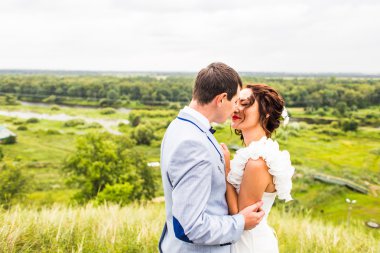 Gelin ve damat gün açık havada yürüyüş düğününde Doğa bahar. Yeşil park kucaklayan mutlu yeni evli.