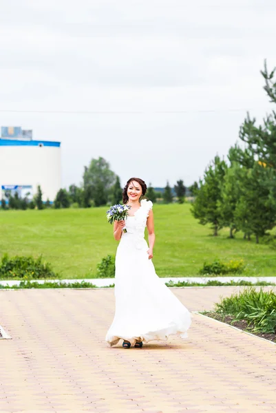 Noiva segurando buquê de lírios calla brancos e flores azuis — Fotografia de Stock