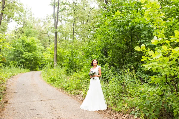 Sposa che tiene bouquet di gigli di calla bianchi e fiori blu — Foto Stock