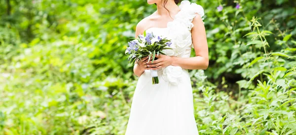 Braut hält Strauß weißer Calla-Lilien und blauer Blumen — Stockfoto