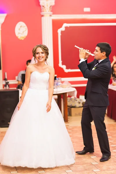 Groom playing a flute for his bride. Wedding party — Stock Photo, Image