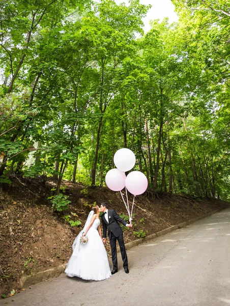 Brudgummen och bruden med ballonger — Stockfoto