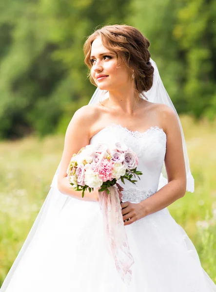 Schöne Braut mit Blumenstrauß im Freien — Stockfoto