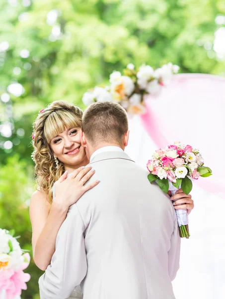 Feliz casal romântico recém-casado dançando no corredor do casamento com decorações e flores rosa — Fotografia de Stock