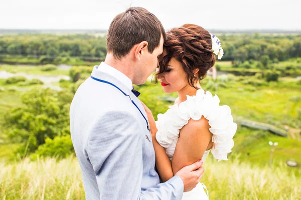 Hochzeitspaar umarmt und küsst — Stockfoto